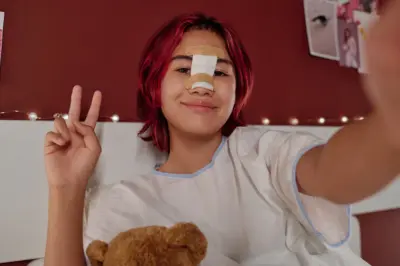 Patientin in der Heilungsphase nach einer Nasenkorrektur in der Türkei, mit Nasenschiene und Pflaster, lächelnd mit Victory-Zeichen